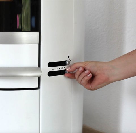 Zbliżenie boku białego pieca na drewno Scan 83-2 i kobiecej dłoni regulującej zawory powietrza