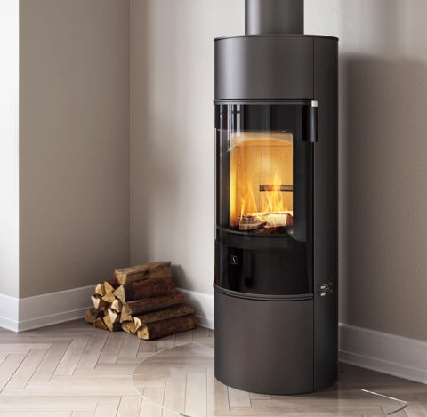 Czarny kominek Scan 84 ze szklanymi drzwiami i możliwością obracania podstawy, w jasnym salonie w stylu skandynawskim